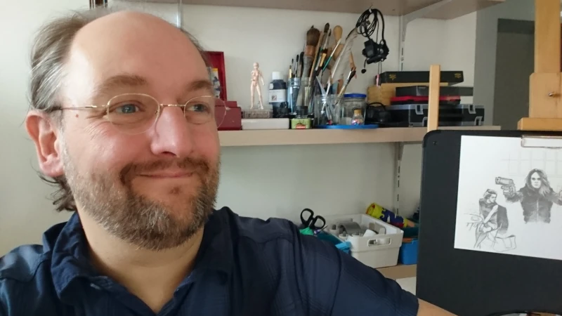 Photo de Alex souriant dans son atelier de dessin
